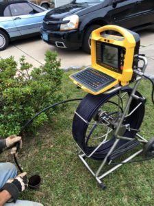 A man is using a laptop to work on the ground.