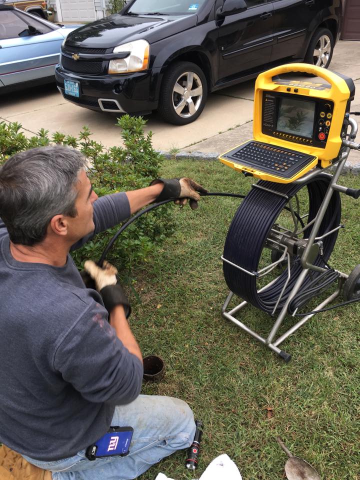 A man is using a laptop to inspect the grass.